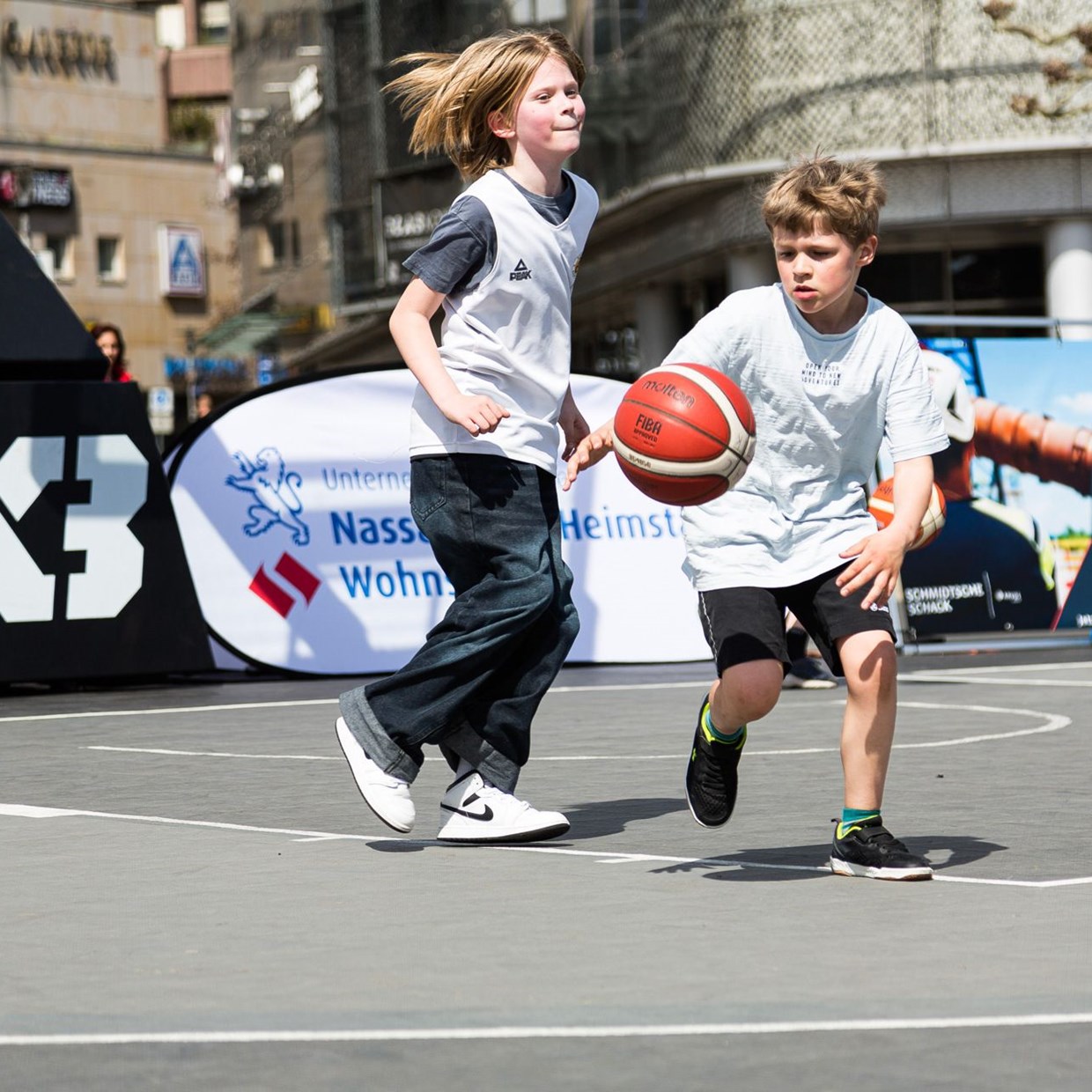 Zwei Minderjährige Jungen, die draußen Basketball spielen.
